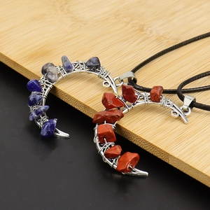 Handmade wire-wrapped crescent moon crystal pendants with woven cords on wood