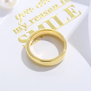 Gros plan détaillé d'une bague minimaliste dorée en acier inoxydable sur carte cadeau