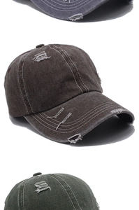 Dettaglio del cappellino in denim vintage con bordi sfrangiati e dettagli strappati