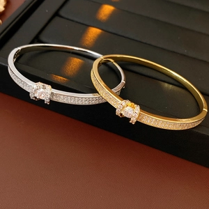 Detailed view of silver and gold plated oval belt buckle bangles with full crystal inlay