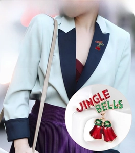 Detail of red enamel Jingle Bells brooch with a green bow and festive holiday lettering