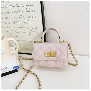 Detail of pink quilted crossbody bag with gold chain strap on minimalist white background