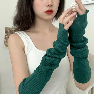 Detail of dark green knitted arm sleeves featuring classic vertical ribbed texture