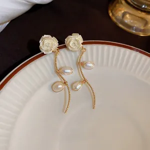 Detailed close-up of French vintage rose earrings with gold twisted chains and oval pearls