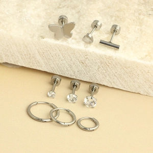 Detailed set of silver stainless steel earrings including bow, heart, and stud designs