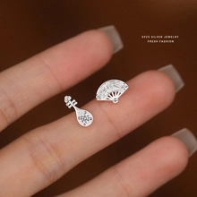 Detailed close-up of S925 sterling silver pipa and fan earrings with traditional motif