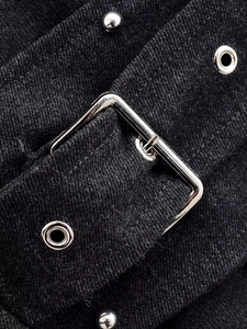 Close-up of silver metal buckle and rivets on black asymmetric dress strap