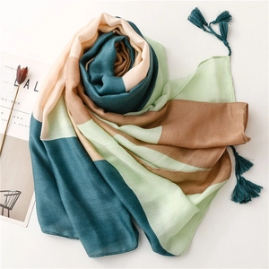Detail of elegant color-block scarf with geometric fringe and textured linen fabric