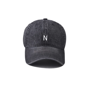 Detailed front view of washed black denim baseball cap with white embroidered N letter