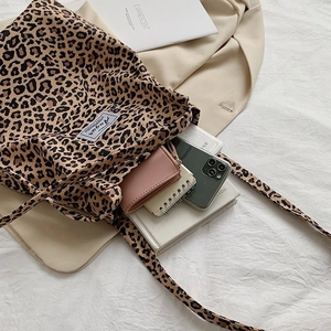 Detailed view of leopard print canvas tote bag showing interior space and woven label