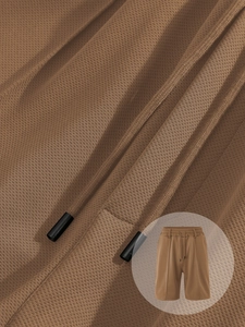 Detail of brown breathable waffle fabric on men's casual shorts with adjustable drawstring