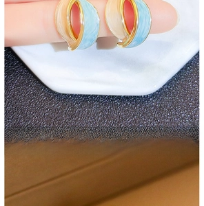 Detailed close-up of vintage French irregular enamel earrings in blue and cream