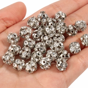 Close-up of sparkling rhinestone paved alloy spacer beads held in a person's palm