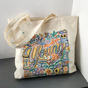 Detailed embroidery on off-white canvas tote bag featuring Young and Humblepie lettering