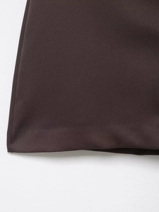Detailed close-up of dark brown fabric texture and neat hem stitching on the skirt pants