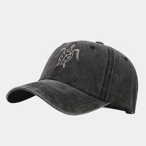 Detailed close-up of a vintage washed grey baseball cap with sea turtle embroidery