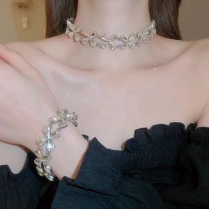 Close-up of sparkling heart teardrop crystal necklace and bracelet set on a female model