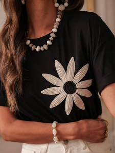 Slim fit black T-shirt featuring a large handcrafted cream 3D crochet floral appliqué