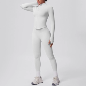 Dettaglio della giacca yoga grigia con zip, asole per pollici e leggings fitness a vita alta