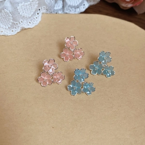 Détails des boucles d'oreilles fleurs en résine rose et bleue avec finition émail