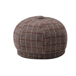 Detailed close-up of brown checkered newsboy cap made of textured wool fabric