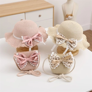Close-up of children's straw sun hat and matching floral bag set in pink and beige