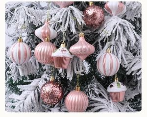 Pink and white Christmas ball ornaments on flocked tree branches with glitter detail