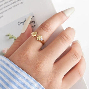 Nahaufnahme eines goldenen Katzenpfoten-Rings mit Herz-Zirkonia am Finger
