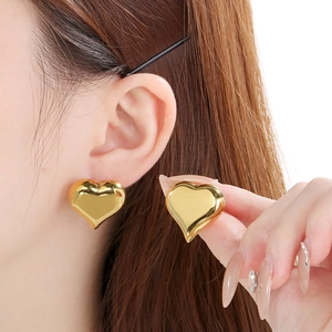 Gros plan de boucles d'oreilles cœur plaquées or 18 carats avec lustre métallique 3D