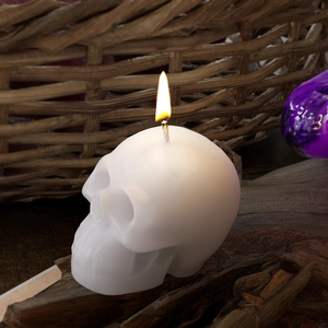 Brandende schedel geurkaars op boomschors voor een rustieke Halloween sfeer decor