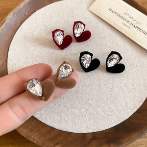 Macro shot of flocked heart earrings in red, black, and brown with drop shaped crystals