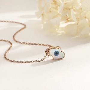 Detail of rose gold evil eye necklace with white shell inlay and elegant O-chain