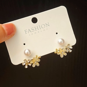 Detailed shot of double flower stud earrings with sparkling rhinestones and white pearl