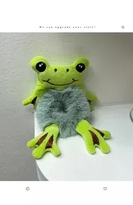 Close-up of cute green frog plush hair scrunchie with soft velvet texture and funny eyes