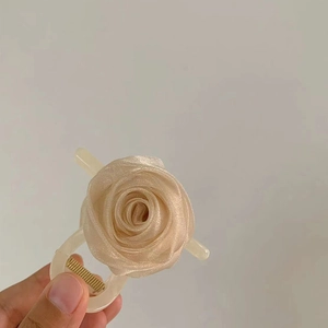 Gros plan sur la pince à cheveux rose en organza champagne aux pétales élégants
