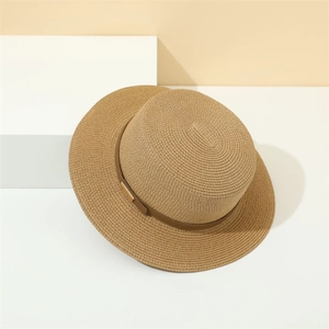 Detail of a brown flat top straw boater hat with fine woven texture and decorative band