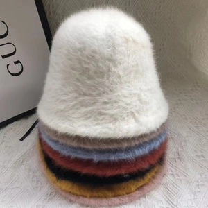 Stack of multi-colored fluffy rabbit fur bucket hats for women in various winter shades