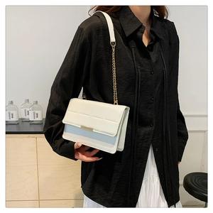 Elegant white chain shoulder bag with minimalist embossed lines and gold buckle detail