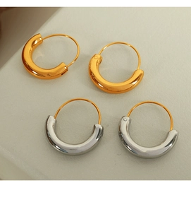 Macro view of gold and silver chunky hoop earrings with high-polish finish on flat background