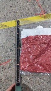 Detail showing red non-woven Christmas chair cover dimensions measured by tape ruler