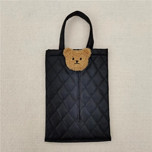 Detail of black quilted leather tissue holder with a cute brown plush bear ornament