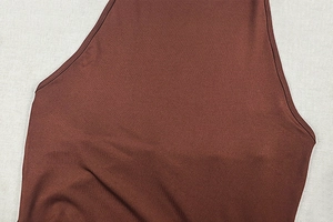 Vue macro détaillée du tissu en maille côtelée marron et des coutures d'une robe ajustée