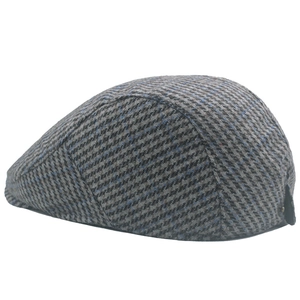 Detailed side view of houndstooth wool newsboy cap with grey and blue plaid texture