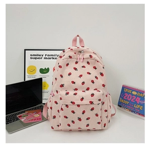 Detail of pink corduroy backpack with strawberry print featuring a large front zipper pocket