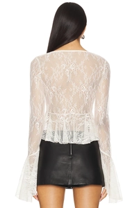Dettaglio del top in pizzo bianco e della gonna in pelle nera con cerniera metallica