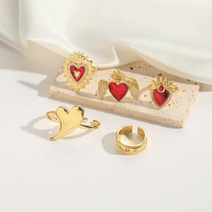 5-piece set of elegant gold rings featuring red hearts and angel wing accents on stone