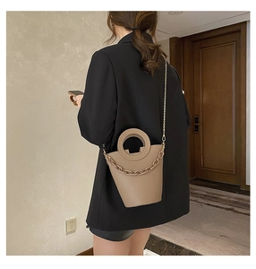 Model view of khaki PU leather bucket bag with circular handle and decorative thick chain