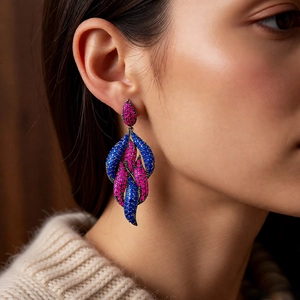 Detail view of vintage leaf earrings with blue and red pavé crystals on a model