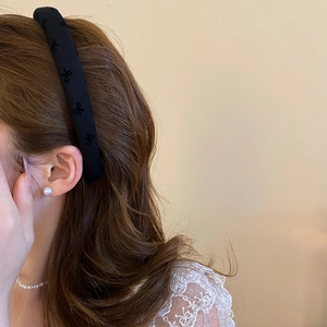 Detail showing black headband with textured bow relief pattern for high-top styling