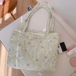 Detail of floral quilted tote bag with diamond stitching and woven fabric label